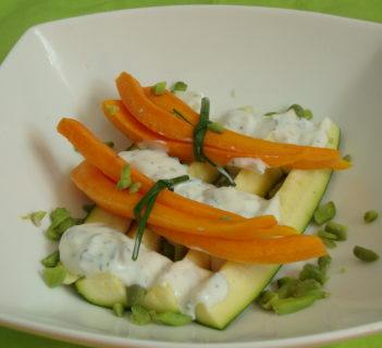 Bukiet młodych marchewek podanych na cukinii